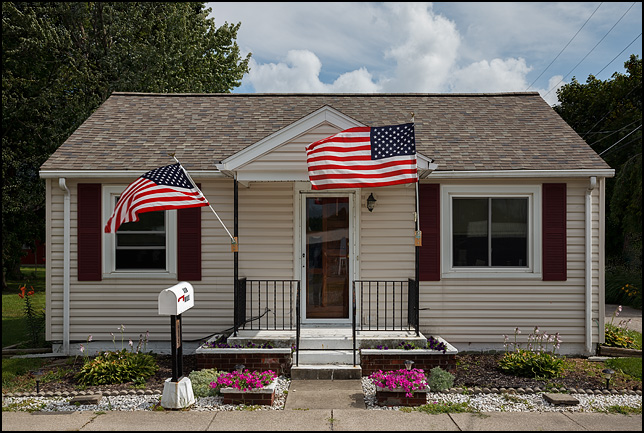 Two large American flags fly from the front of a house on Mill Street in the small town of Churubusco, Indiana.