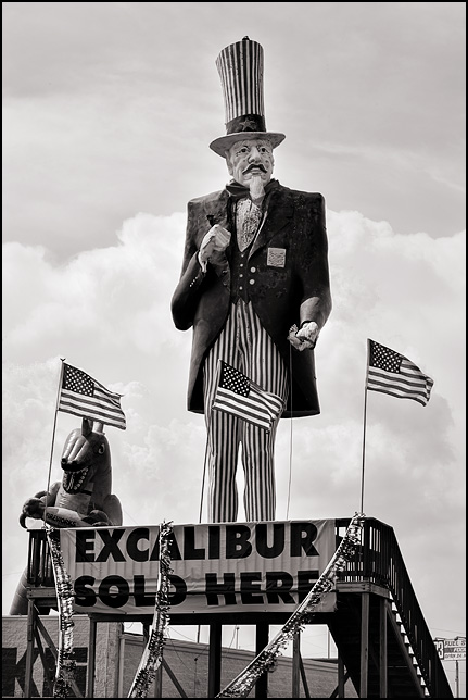 A huge statue of Uncle Sam and an inflatable Godzilla surrounded by American flags at a fireworks store in Ottowa Lake, Michigan.