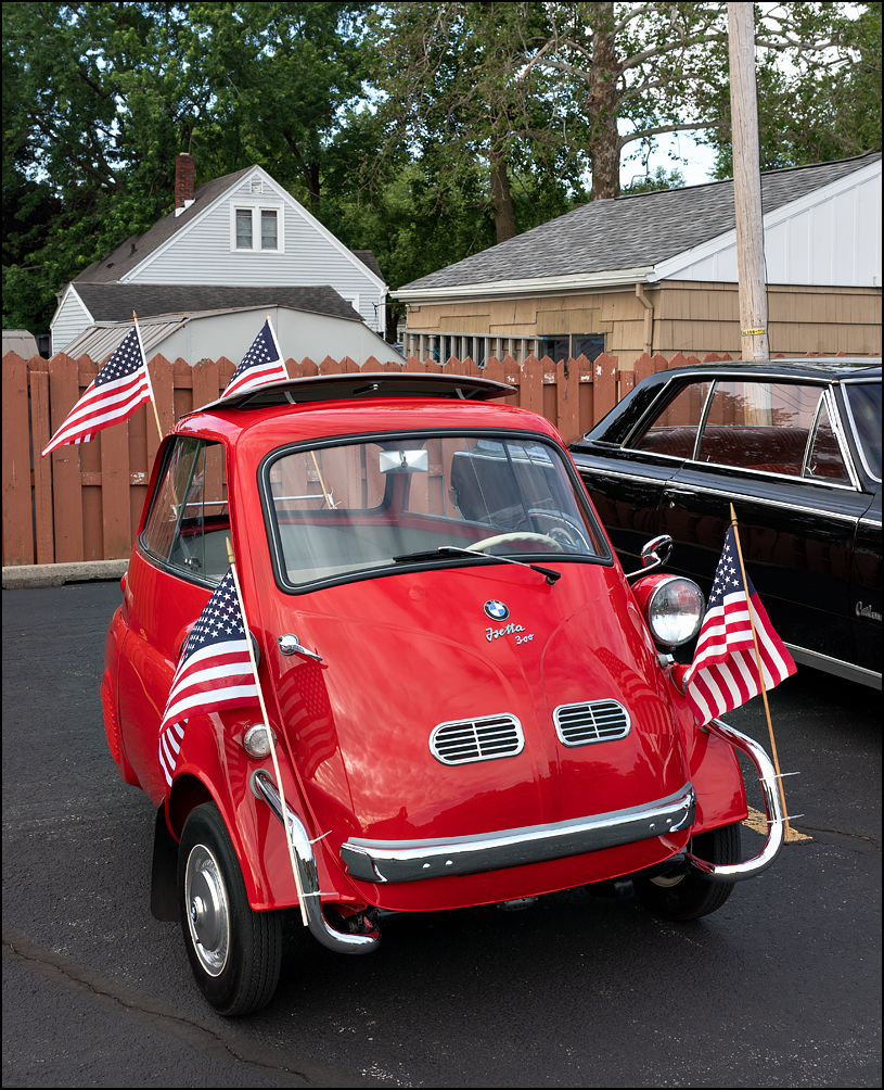 A red 1957 BMW Isetta 300, decorated with American flags sits in the staging area before the start of the 2023 Waynedale Memorial Day Parade in the Waynedale area of Fort Wayne, Indiana.