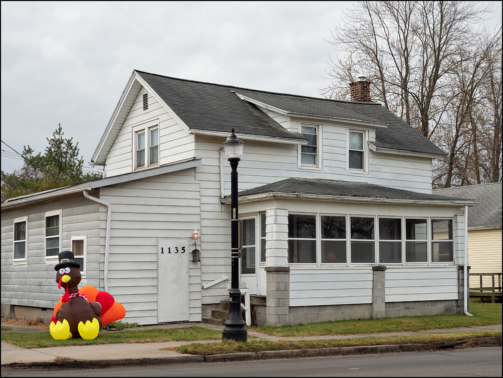 An inflatable turkey for Thanksgiving in front of an old white house on West Main Street in Fort Wayne, Indiana.