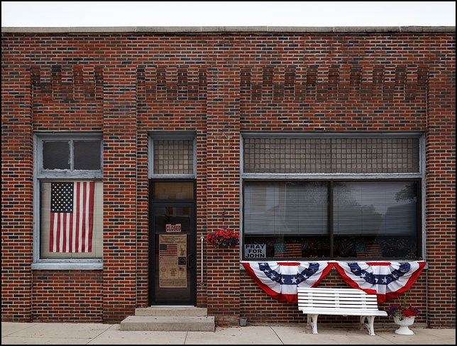 Patriotic bunting and American flags adorn the windows of the Village Office in the small town of Willshire, Ohio.