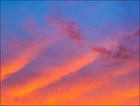 Abstract photographs of diagonal lines of red and orange clouds in a dark sky at sunset on an August evening in Indiana.